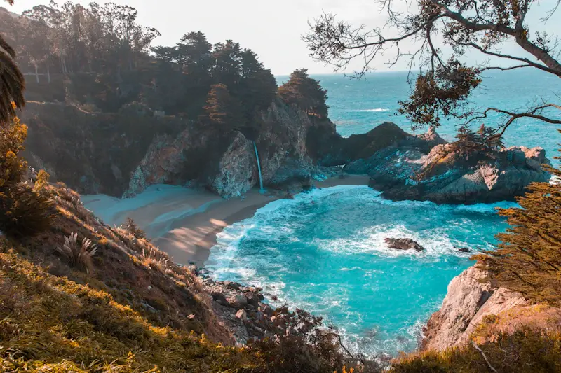 Crique rocheuse et eau turquoise entourées de végétation