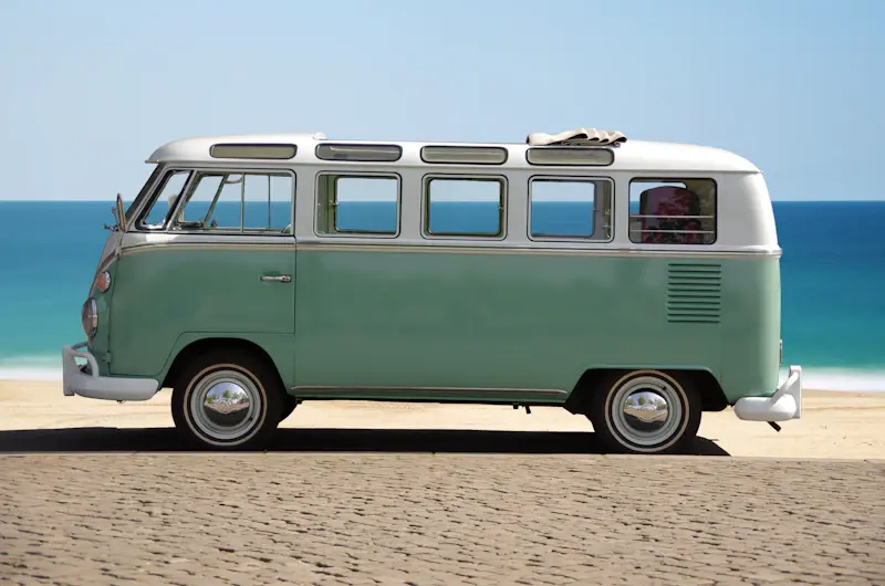 Minibus garé sur une plage au bord de l’eau turquoise